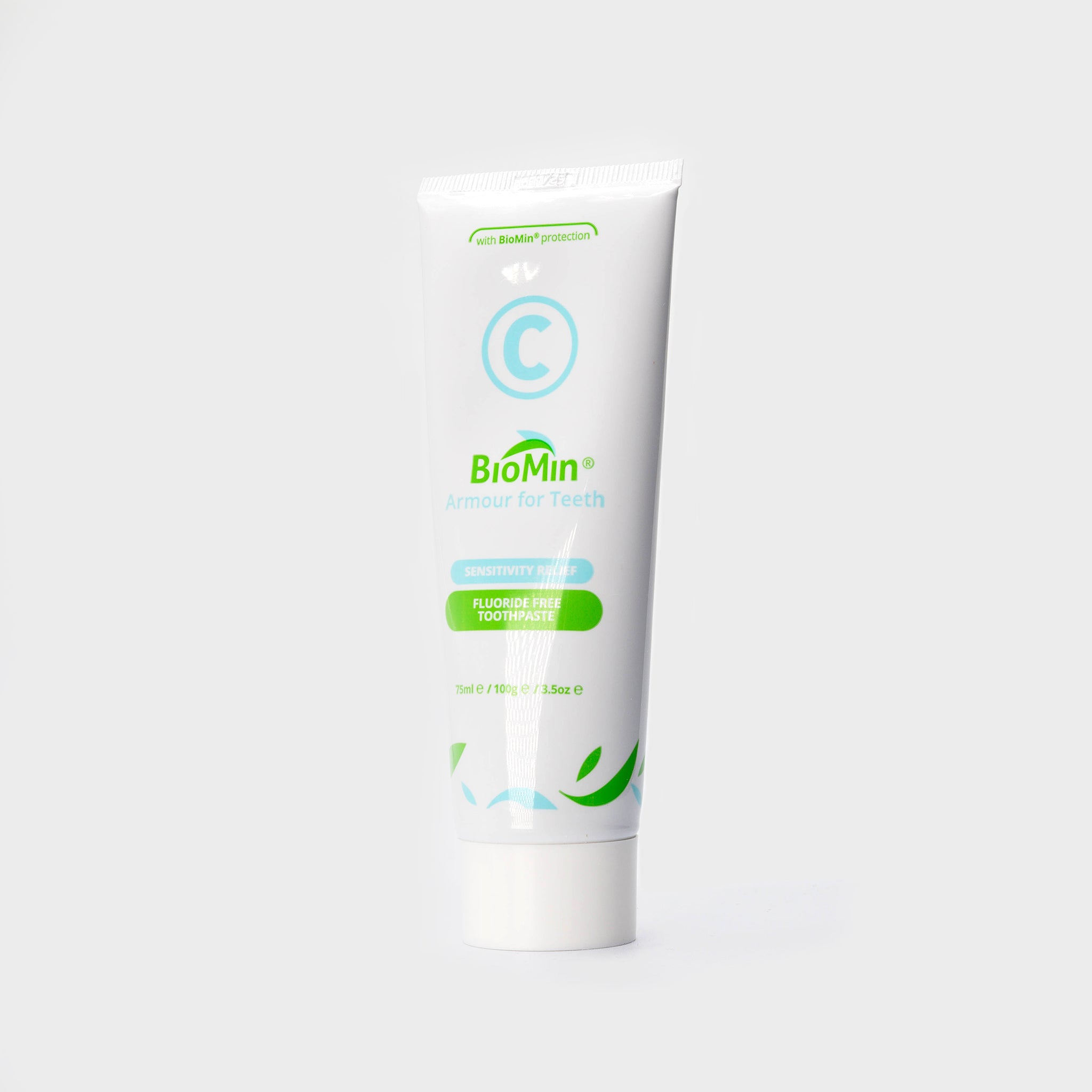 A white tube of BioMin C toothpaste, slightly turned to its left, labeled "Armour for Teeth" with fluoride free protection. The tube features green leaf designs and a prominent blue "C" symbol, indicating fluoride free content.