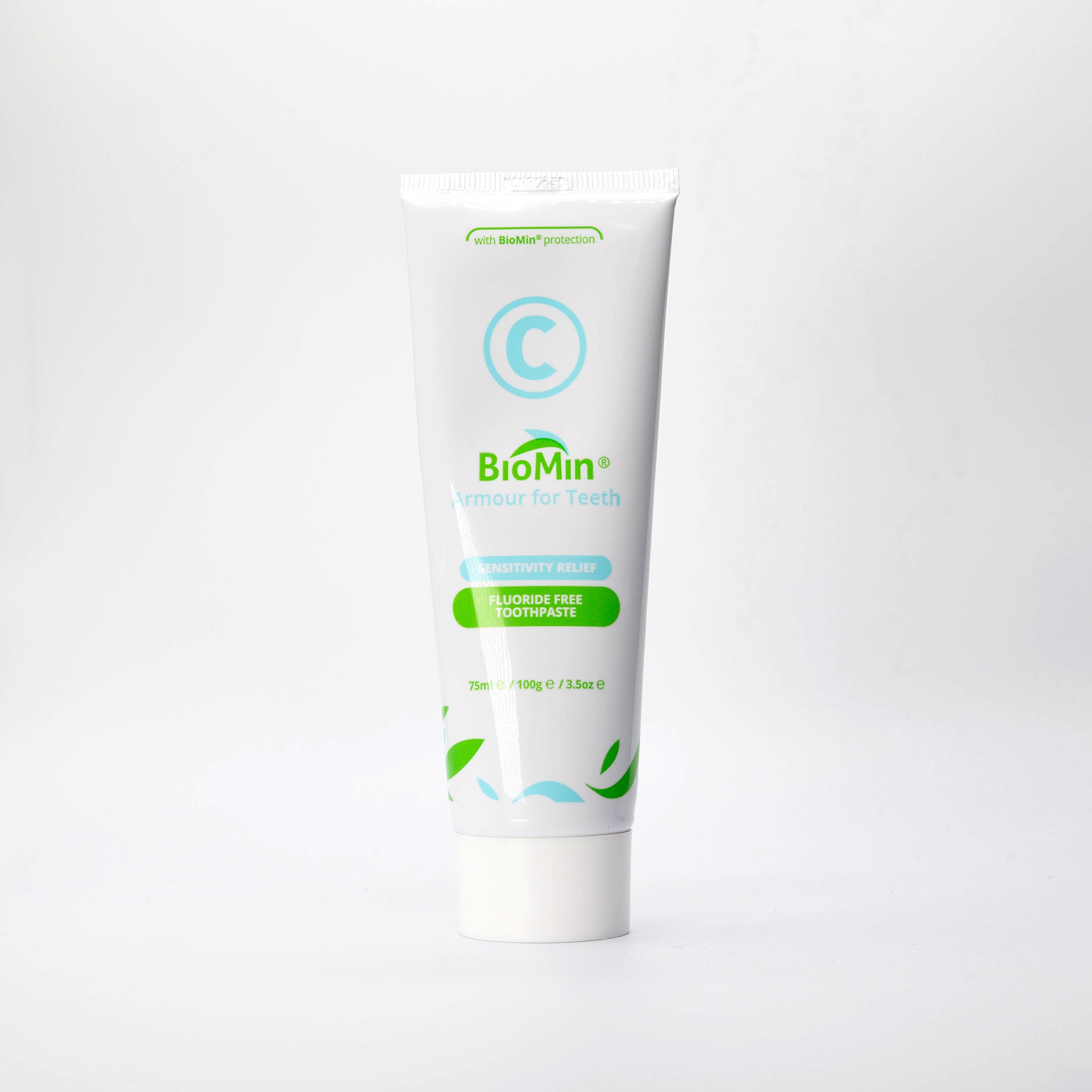 A white tube of BioMin C toothpaste labeled "Armour for Teeth" with fluoride free protection. The tube features green leaf designs and a prominent blue "C" symbol, indicating fluoride free content.